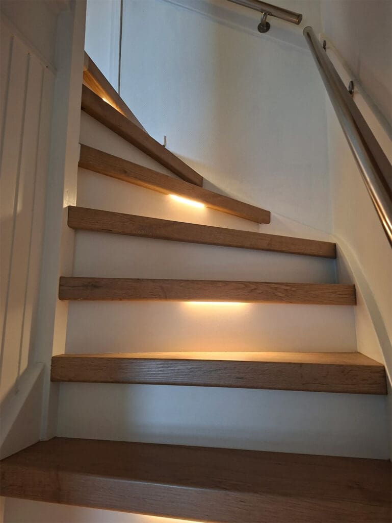 traprenovatie met witte stootborden, verlichting en decor toscana